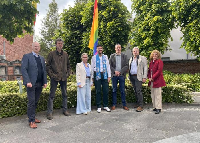 foto schepencollege tijdens uithangen van regenboogvlag bij GC Sint-Jozef