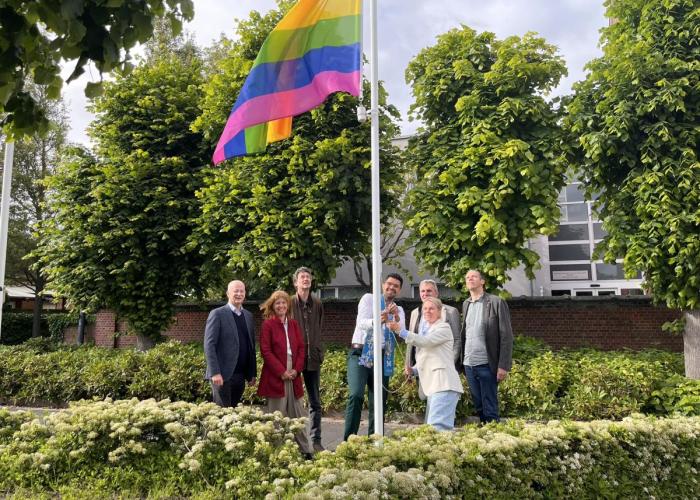 foto schepencollege tijdens uithangen van regenboogvlag bij GC Sint-Jozef
