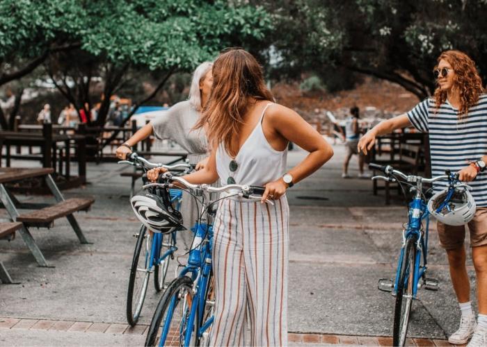 twee dames stappen naast fiets