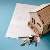 Op deze afbeelding zie je een huis, een sleutelbos en een document